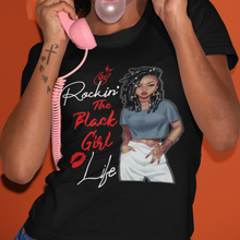 Load image into Gallery viewer, Young African American Black Woman on a black t-shirt with locs/dreds wearing a crop top and white pants. With the words Rockin' the black girl life.