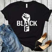 Load image into Gallery viewer, Black t-shirt with a fist and the word black in white color and AF in black color on the arm of the fist. Black shoes and blue jeans are in the bottom corners.
