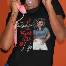 Load image into Gallery viewer, Young African American Black Woman on a black t-shirt with locs/dreds wearing a crop top and white pants. With the words Rockin&#39; the black girl life.
